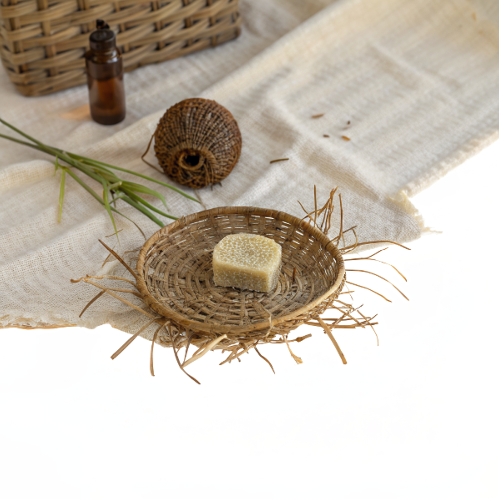 Porte-savon rond en vétiver naturel posé sur un lavabo, diffusant un parfum apaisant et authentique