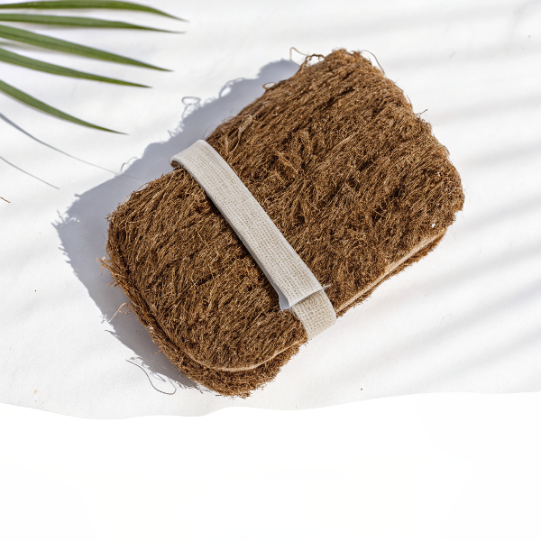 Application du gant de douche exfoliant en vétiver tressé main sur la peau pour un nettoyage profond, revigorant et relaxant sous la douche