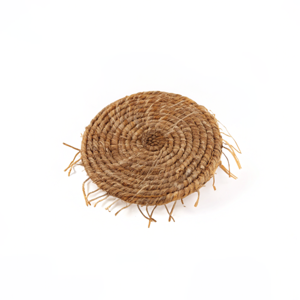 Porte-savon artisanal en vétiver rond, aux racines tressées à la main, posé sur un fond clair