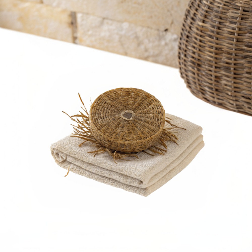 porte-savon vétiver rond avec savon posé, permettant un égouttage sans eau stagnante et diffusion d'un parfum relaxant discret