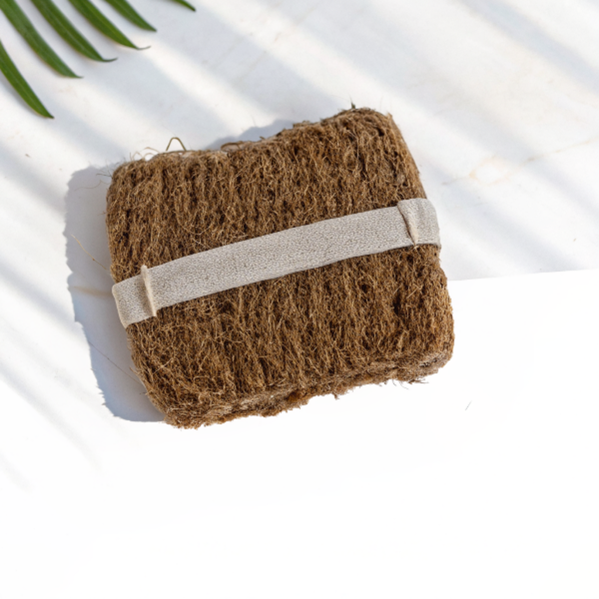 Gros plan sur la texture brute respectueuse en vétiver tressé main du gant de douche exfoliant, idéal pour une exfoliation douce sans produits chimiques